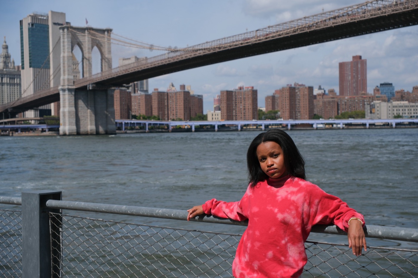 Dakotah Jennifer on the East River waterfront with the Brooklyn Bridge behind her