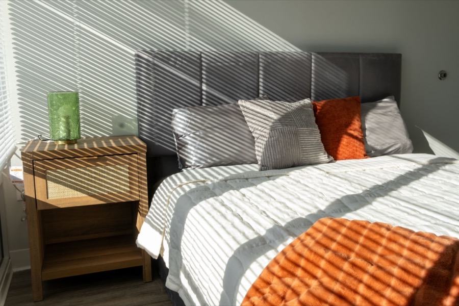 Bedroom nightstand with a green glass lamp in afternoon light